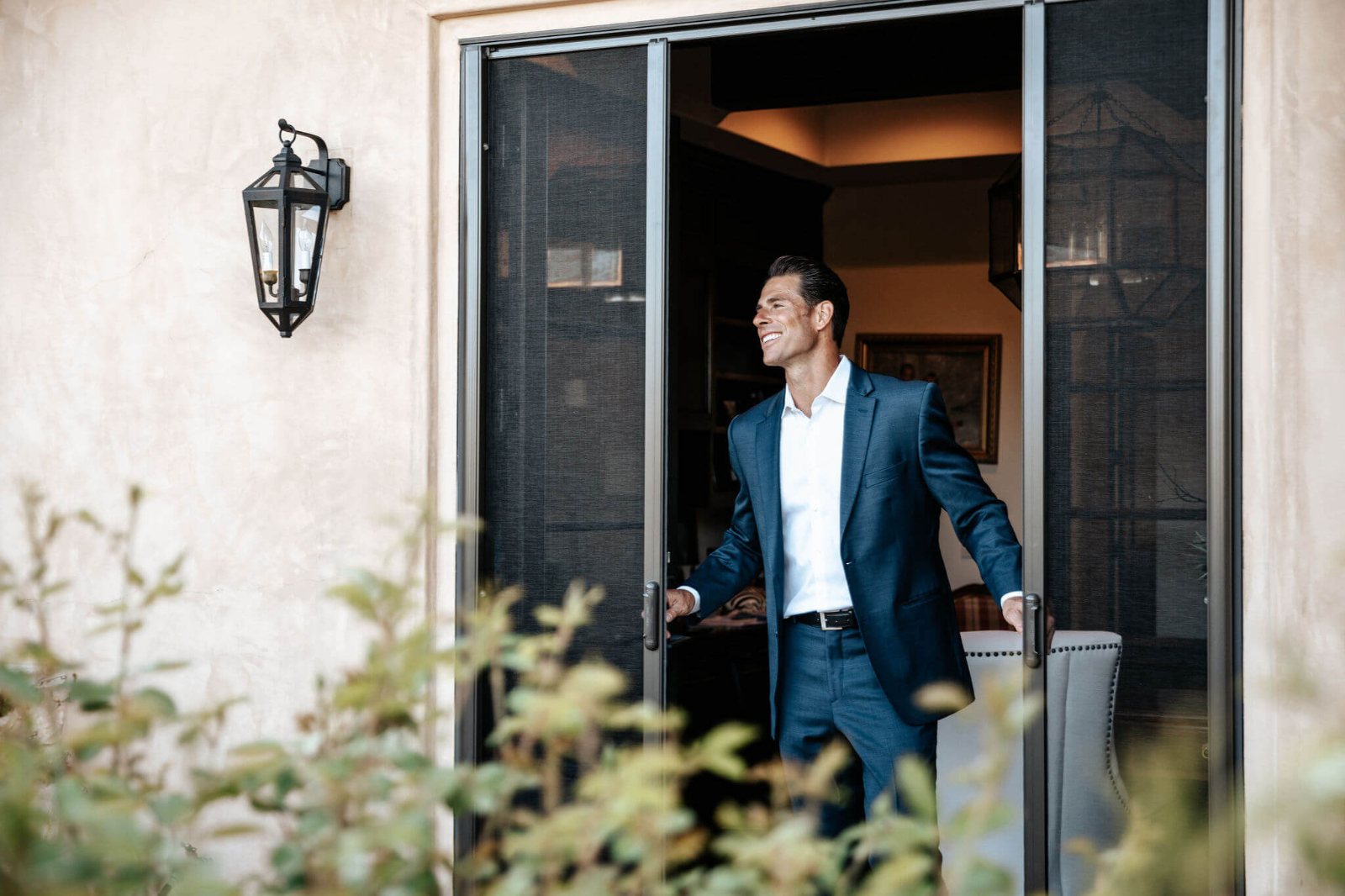 Professional stepping through a retractable screen door in warm evening light